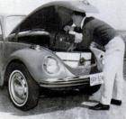 man fitting luggage in frunk of Super Beetle
